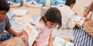 Niños van a la playa leyendo