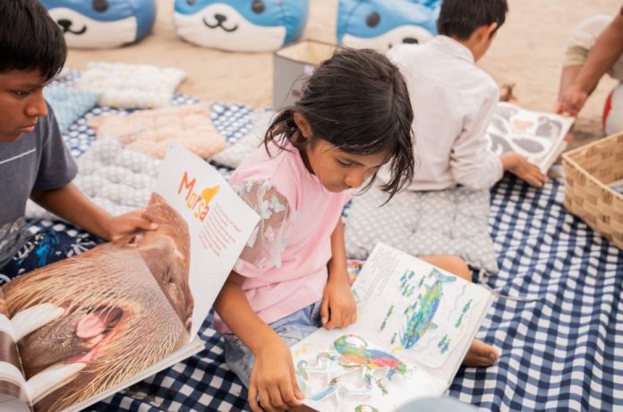 Niños van a la playa leyendo
